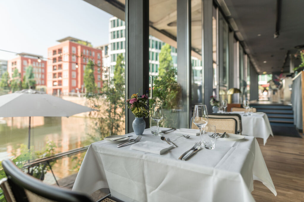 Gedeckter Tisch im Restaurant Frankfurter Botschaft im Westhafen Brückengebäude mit Blick auf das Hafenbecken