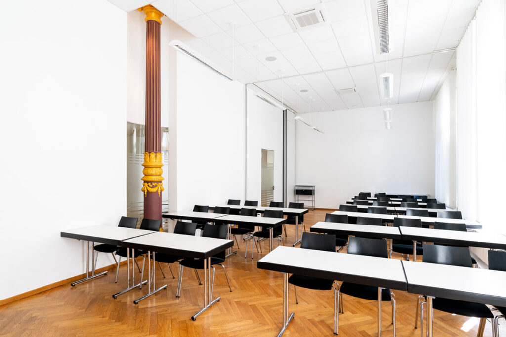 Schulungsraum mit parlamentarischer Bestuhlung und historischer Säule im Bürohaus Hannover